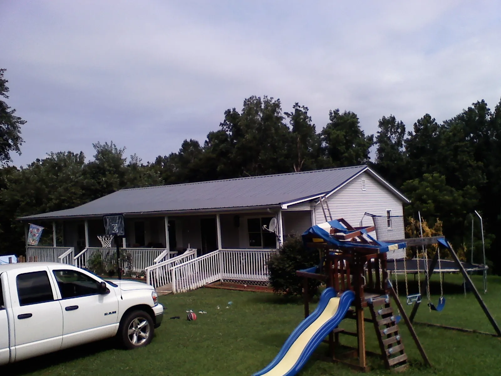 Dark metal roof on a country home with a full length front porch in Medford